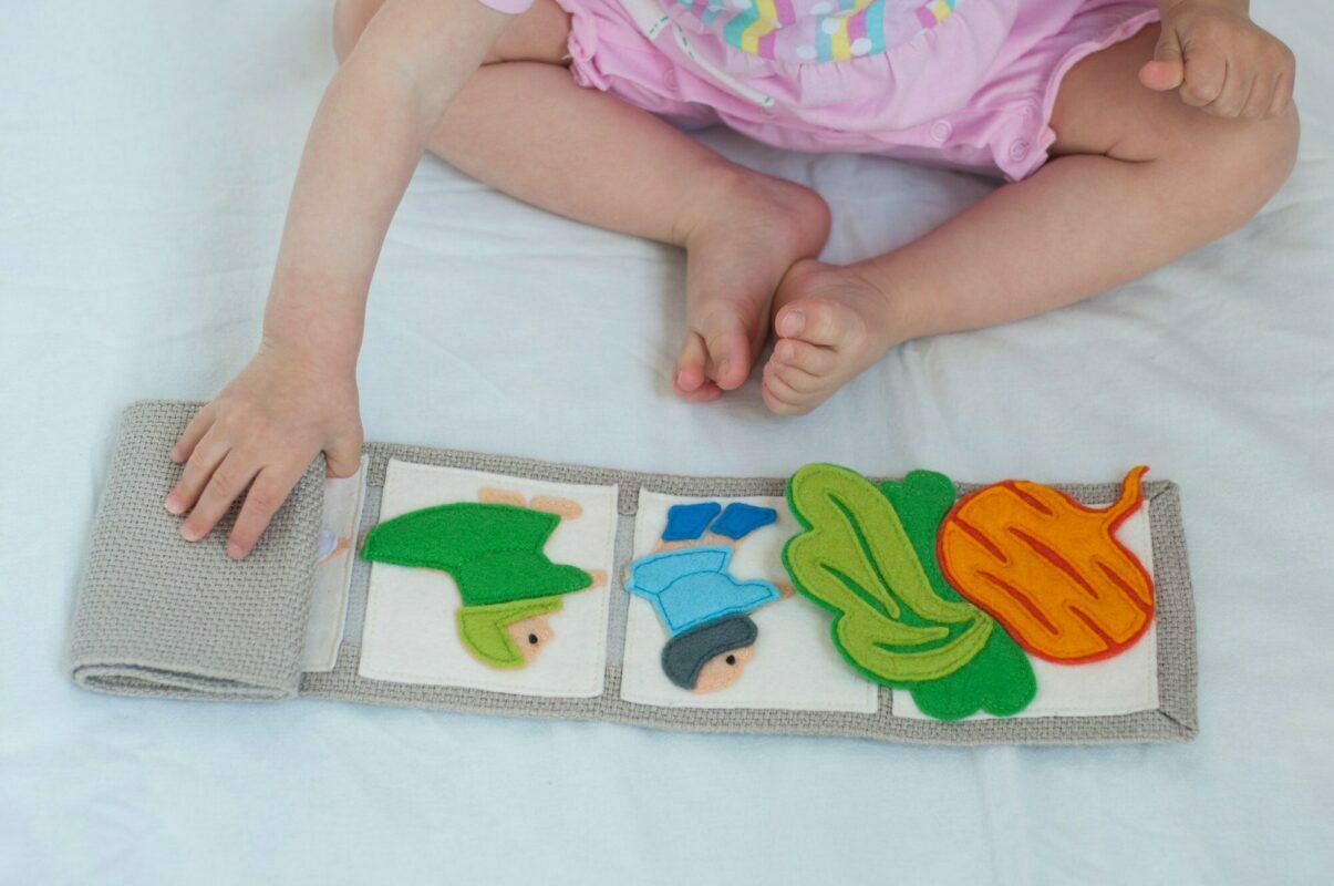 Baby playing with handmade textile book